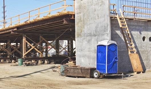 multiple portable toilets arranged at a busy job site